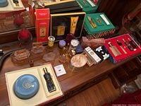 Overview of lot on dresser, showing various perfume bottles, boxes and accessories