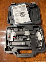 Porter Cable pin nailer, model PIN138, with user manual, carrying case, and safety glasses inside case.