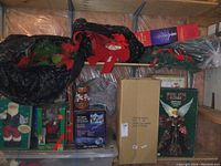 Shelf with various boxed Christmas decorations including Santa figures and fiber optic angel boxed decorations