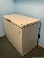 Side and top view of the white chest freezer showcasing its size and locked lid
