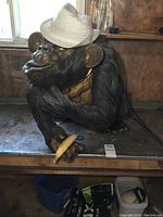 Front three-quarter view of seated ape sculpture on workbench