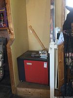 Photo including top rails stacked upright along wall behind the cabinet and posts.