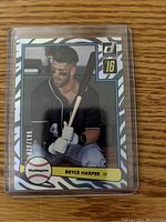Front image of the Bryce Harper baseball card in protective sleeve showing holofoil pattern, player photo, and numbered 29/199.