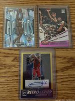 Three NBA basketball cards with autographs and serial numbers, clearly showing the players: Joakim Noah, Grant Hill, and Anfernee Hardaway in protective sleeves.