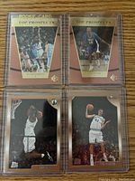 Four basketball rookie cards housed in protective holders. Two cards labeled 'Rookie Card Top Prospects' featuring Paul Pierce and Antawn Jamison, and one Top Prospects card of Dirk Nowitzki. Another card shows Paul Pierce performing a basketball move near the net, a Topps card with a darker background.