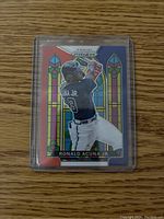 Front of Ronald Acuna Jr baseball card with stained glass red, white, blue design, showing the player batting.