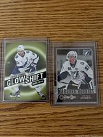 Two Steven Stamkos rookie hockey cards in protective sleeves. Left card is Glow Shift synergy brand insert with green background, right card is Marquee Rookies OpacStar card in monochrome design.