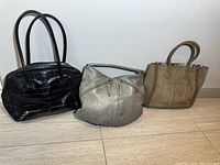 Photo showing the three leather purses: black croc pattern handbag, silver leather purse, and brown suede handbag.