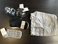 Overview of five pairs of socks and folded gray T-shirt showing part of a black and white printed design.