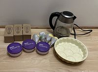 Three vintage-style 60W incandescent mood light bulbs in cardboard boxes plus three modern LED light bulbs, three small purple seasoning containers, an electric glass kettle, and a cream ceramic egg tray.