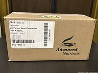 Closed cardboard box labeled with SKU, product description, and brand Advanced Nutrients containing the fertilizer liquid bottles.