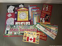 Overview of educational posters, charts, signs, flashcards, and banners arranged on floor.