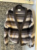 Front view of TNA women's cardigan hanging on black hanger showing horizontal striped pattern and button closure