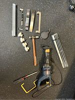 Full lot overview including Ryobi saw and assorted tool accessories arranged on black surface