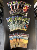Photo showing 15 vintage Superman comic books separated into three groups of five issues each on a dark surface.