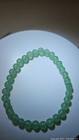 Top view photo of green aventurine bead stretchy bracelet showing round beads and elastic string.