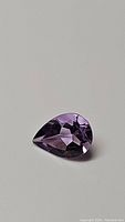 Top view of 1.63 carat natural Brazilian purple amethyst pear shaped gemstone showing color and faceting