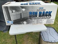 Box showing packaging for Cedral steel bin rack with large plastic bins including branding and product name.