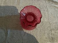 Top view showing the ruffled flared rim and textured diamond pattern inside the cranberry glass vase.