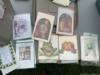 Photo showing an assortment of greeting cards with envelopes, featuring various designs like Christmas, floral, clock, birds, frogs, and motivational quotes.