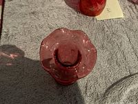 Top-down view showing ruffled open top of ruby red vase