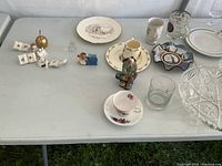 Wide view of the assortment of glassware, ceramic cups, plates, and decorative figurines on tables