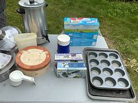 Full view of kitchen items including brie baker, muffin pans, measuring cups, thermos, Ziploc bags