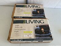 Two boxed maple firepit rings stacked on white surface, boxes show product image and labeling