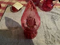 Top view of the cranberry glass jack-in-the-pulpit vase showing leaf-like flared opening and ribbed texture on the glass.