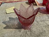 Vintage Fenton cranberry pink glass tulip-shaped candle holder seen from side view, showing detailed feather like patterning and petals of tulip shape.