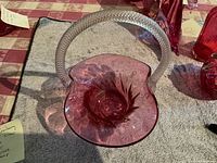 Top view of the cranberry glass basket showing the ruffled rim and clear twisted handle.