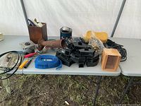 Overview of tote contents on a table showing a variety of hardware, hoses, clamps, plugs, and wiring.