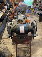 Front view of Ridgid chop saw and Duracraft bench grinder, showing saw blade and grinder wheels.