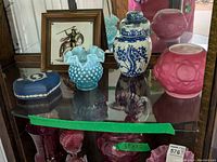 Full view of the lot showing Fenton vase, Wedgewood trinket box, pink and blue ginger jars, and framed tile
