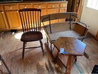 Three pieces of vintage furniture including a wooden spindle back chair, a sleigh style rocking chair with metal supports and a wooden octagon corner table.