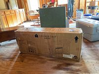 Boxed Twin Star Home TV stand with barn door style design and fireplace insert depiction, showing condition of box and branding.