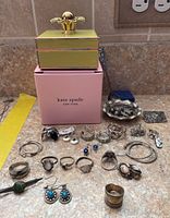 All items arranged on counter including Kate Spade box, jewelry, pins, rings and earrings