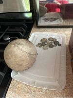 Overall view of vintage softball next to assorted vintage coins on a tray.