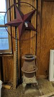Both the vintage Sun stove and the metal star wall decor shown hanging on shed wall, revealing condition and size.