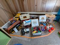 Overall view of the vintage toys, books, and storage boxes in a corner of a room showing various toy figures, wood toys, storage boxes, and children's books.