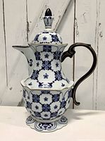 Large blue and white patterned decorative tea/coffee pot with gold edging, curved handle, and scalloped base.