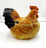 Side front view of hen/chicken shaped ceramic soup tureen with detailed feather painting and small ladle notch.