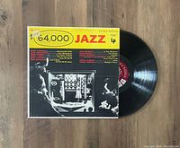 Photo showing the $64,000 Jazz Columbia LP partially out of its cover. Album cover front shows artist names and a black and white photo with yellow and red lettering.