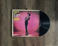 Photo showing the front cover of the album 'St. Louis Blues' by Eartha Kitt with Shorty Rogers and His Giants and the vinyl LP partially pulled out.