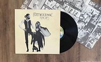 Photo showing the Fleetwood Mac Rumours album cover, black vinyl LP partially pulled out, and the inner sleeve containing black and white photos of the band.