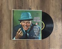 Photo displaying the Frank Sinatra Come Dance With Me LP cover with vinyl partially pulled out, showing record label.