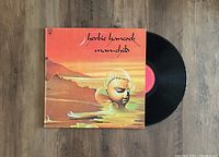 Photo of Herbie Hancock Man-Child vinyl LP with original album cover showing surreal artwork and the vinyl record partially removed from sleeve.