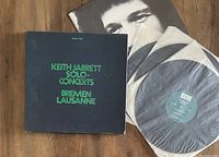 Photo showing the 3LP box set cover with title in green text, one LP partially out of sleeve, and two other LPs with vinyl visible.