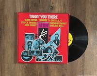 Front cover of the 'Takin' You There' STAX compilation LP vinyl record with the black vinyl partially pulled out, lying on a wooden surface.