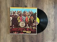 Front view of the Sgt. Pepper's Lonely Hearts Club Band vinyl record partially removed from its cover.